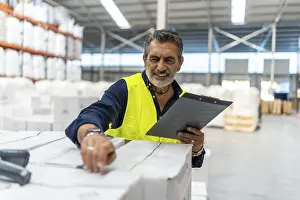 Commercial Logistics Services Imprime: Logistics manager smiling while using a barcode scanner