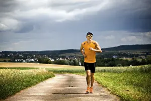 Recreational Activity Imprime: Man jogging through the fields