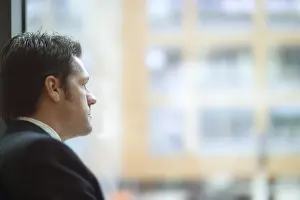 Businessman In Office Imprime: Man looking out