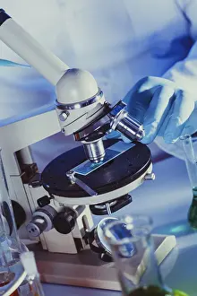 Scientist In Lab Imprime: Man is looking into the ocular of microscope