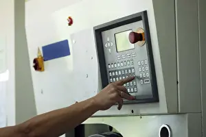 Passenger Traffic Control Imprime: Man presses button on electronic control panel