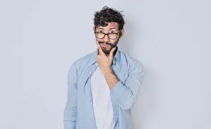 Hispanic Ethnicity Model Imprime: Man rubbing his beard with an expression of doubt