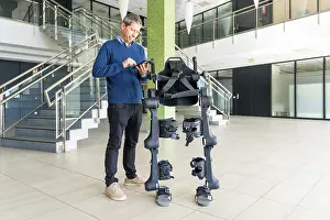 Exoskeleton Technology Imprime: Mechanical exoskeleton computer engineer looking at the robot with a tablet