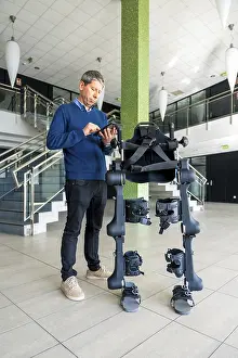 Mechanical Exoskeleton Imprime: Mechanical exoskeleton computer engineer looking at the robot with a tablet