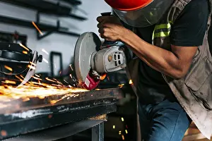 Handicraft Industry Imprime: Metalworking professional using an angle grinder in the workshop