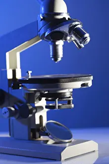 Biotechnology Research Imprime: Microscope on the table in laboratory with blue light