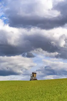Empty Farmland Imprime: Mobile raised hide in an empty field under dramatic clouds