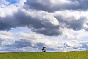 Deserted Farmland Germany Imprime: Mobile raised hide in an empty field under dramatic clouds