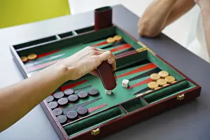 Indoor Leisure Activities Imprime: A player makes a move in a backgammon game