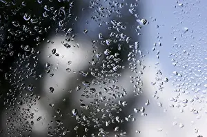 Cloudy Sky With Raindrops Imprime: Rain drops on window as the clouds clear behind