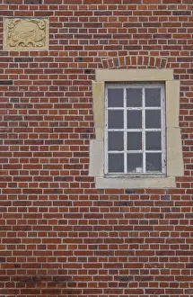 Red Brick Facade Imprime: A rectangular window and a coat of arms in a red brick facade