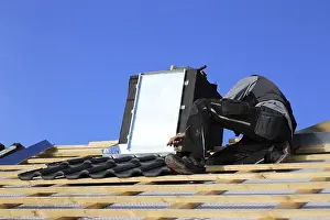 Construction Site Work Imprime: Roofer works on the chimney cladding