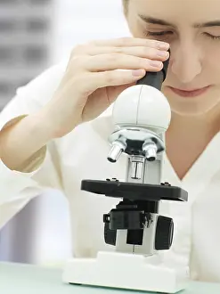 Laboratory Equipment Imprime: Scientist looking through a microscope