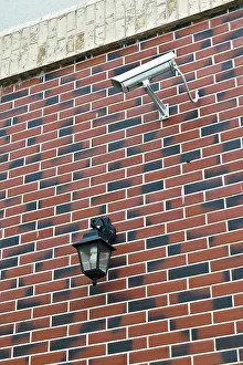 CCTV Camera Installation Imprime: Security camera and flashlight on the wall of the house