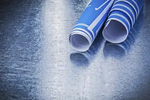 Blue Construction Plans Imprime: Stack of blue construction plans on metallic background building concept