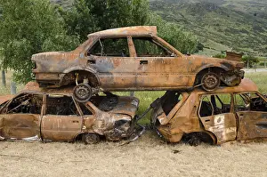 Deserted Junkyard Scene Imprime: Stack of three rusty car wrecks