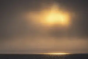 Svalbard Norway Imprime: Sun breaking through clouds, reflection on sea surface