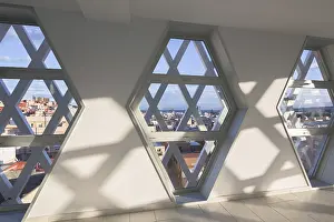 Urban Skyline View Imprime: Sunlight streams through hexagonal windows