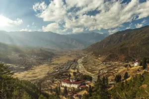 Cloudy Sunset Imprime: Sunrays through the clouds as the sun is setting over Paro