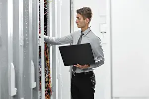 Healthcare Technology Imprime: Technicians using laptop while analyzing server in server room