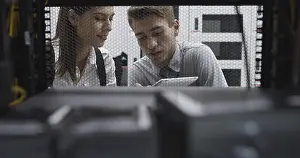 Healthcare Technology Imprime: Technicians using laptop while analyzing server in server room