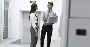 Server Room Technician Imprime: Technicians using laptop while analyzing server in server room