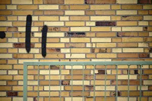 Old Building Architecture Imprime: A wall made of old clinker bricks with an angular railing in front of it