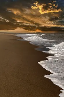 US American Coastal Landscape Imprime: Waves on empty beach, dramatic cloudy sky at sunset