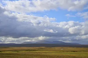Scottish Mountain Photography Imprime: Wide plain with mountain views and dramatic sky with thick clouds