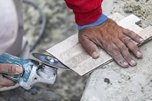 One Person Construction Team Imprime: Worker grinding corner tile for fitting