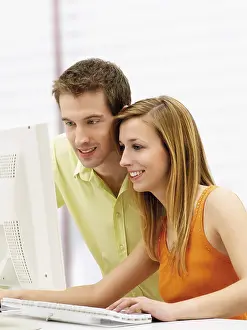 Young Couple Imprime: Young couple using a computer