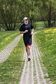Sportsman In Action Imprime: A young man jogging through the fields