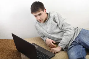 Young Man On Sofa Imprime: Young man with notebook on sofa