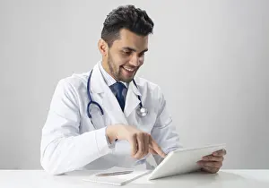 Healthcare Technology Imprime: Young smiling internist using tablet computer